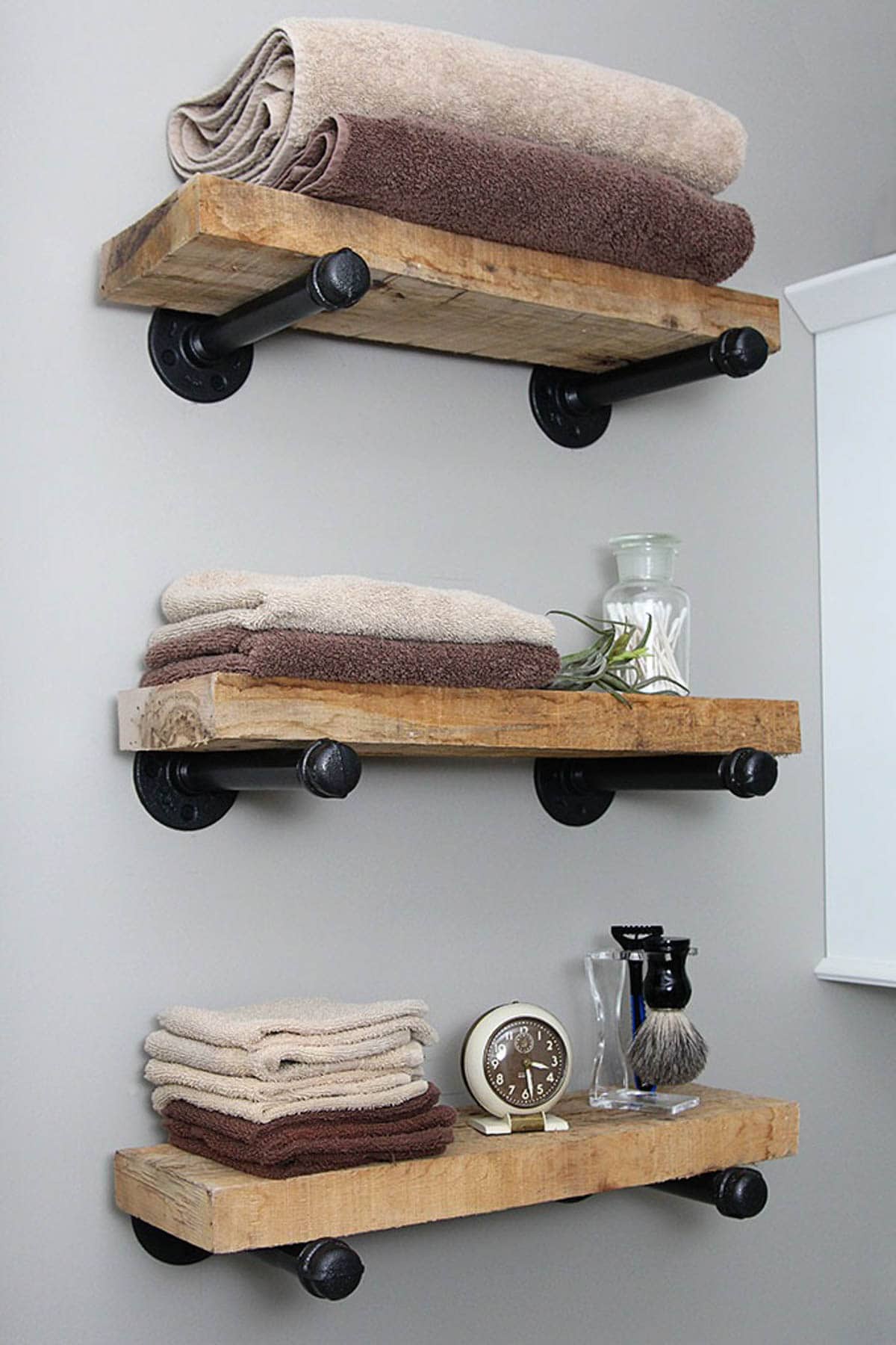 Bathroom wall shelves made with wood and industrial pipe