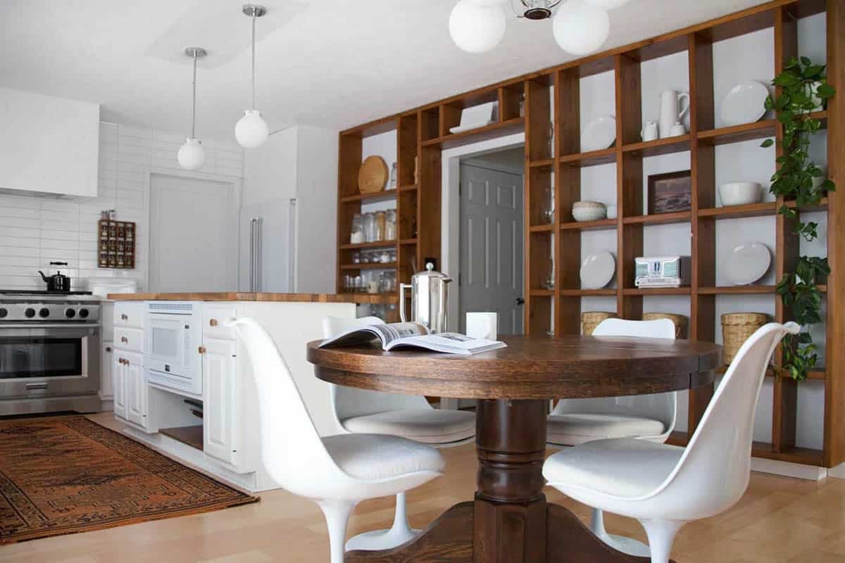 View of dining area and kitchen with wood shelving wall