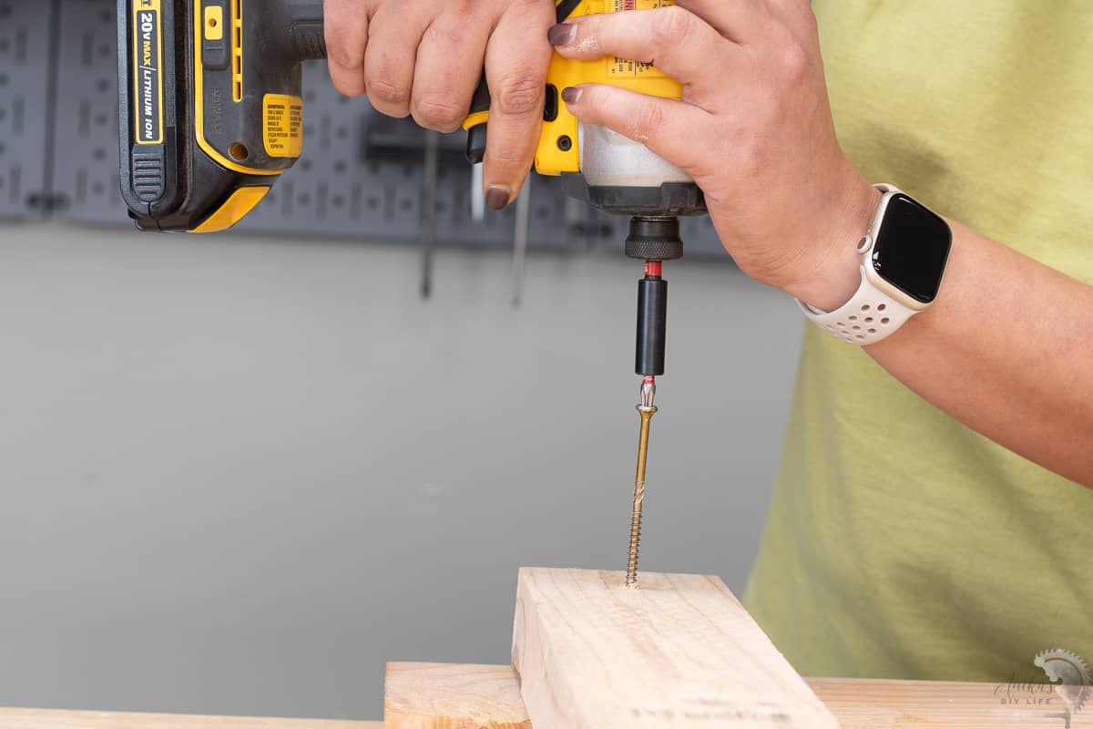 woman driving wood screw into wood boards