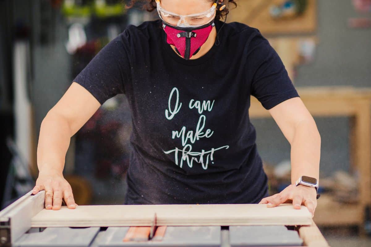 Anika cutting a plywood on a table saw