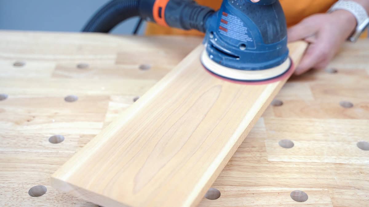 woman sanding a cedar board to build a planter