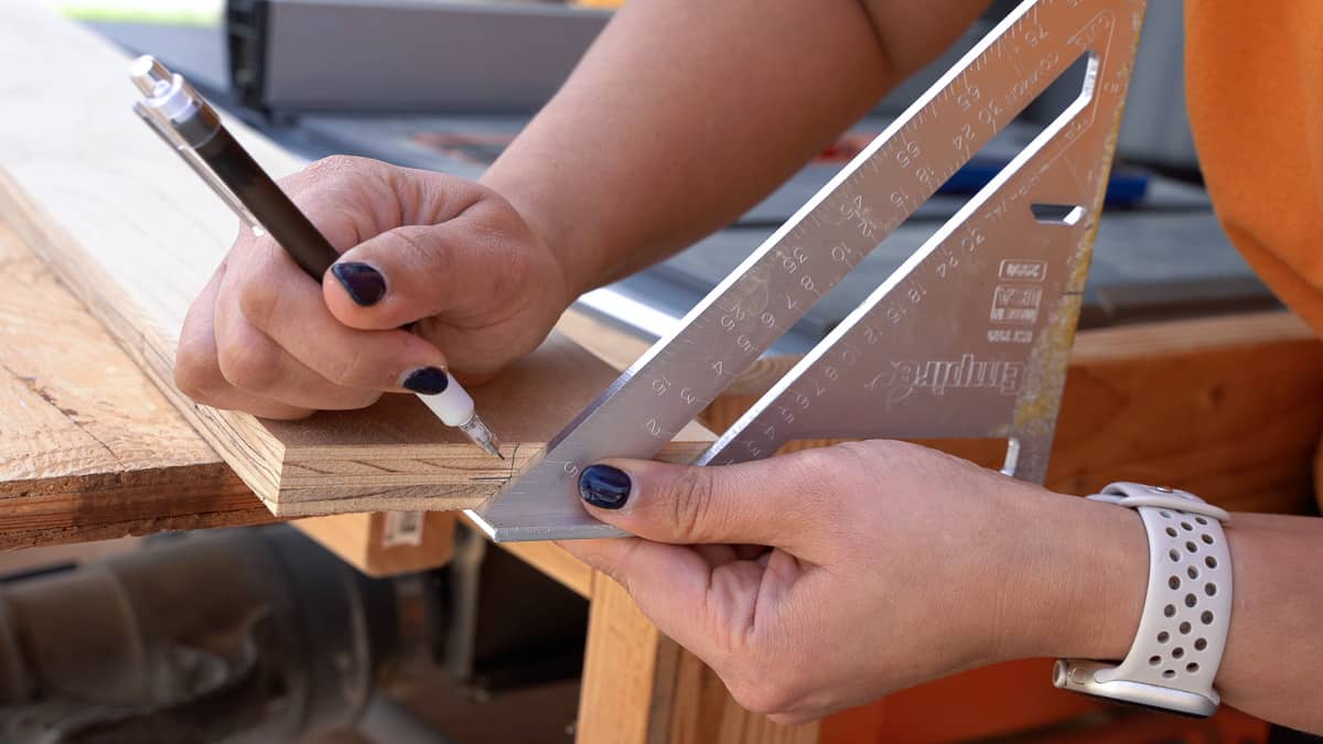 marking the 45 degree angle on the edge of the plywood to make the french cleat