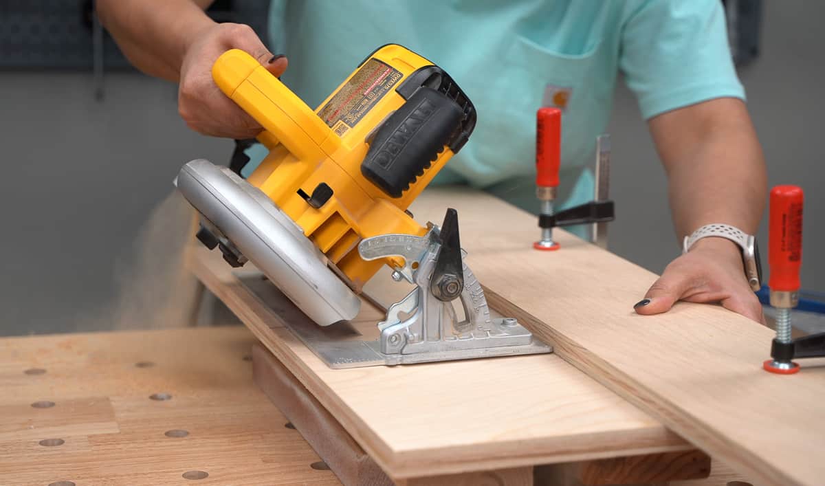 Cutting the plywood at a 45 degree angle using a circular saw to make one part of the french cleat