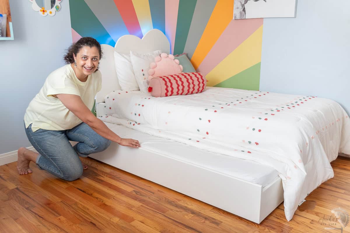 Anika pulling out the trundle bed from under the twin bed.