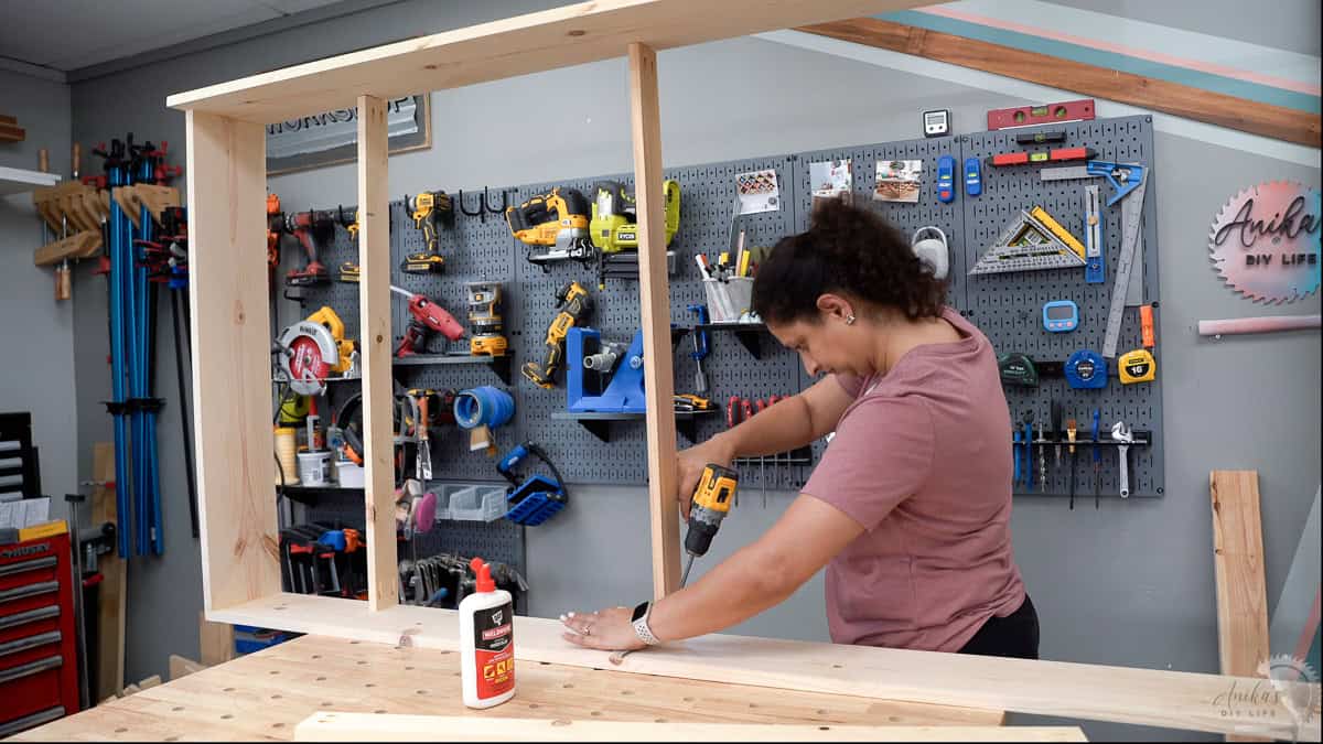 Anika attaching supports to the trundle using pocket hole screws