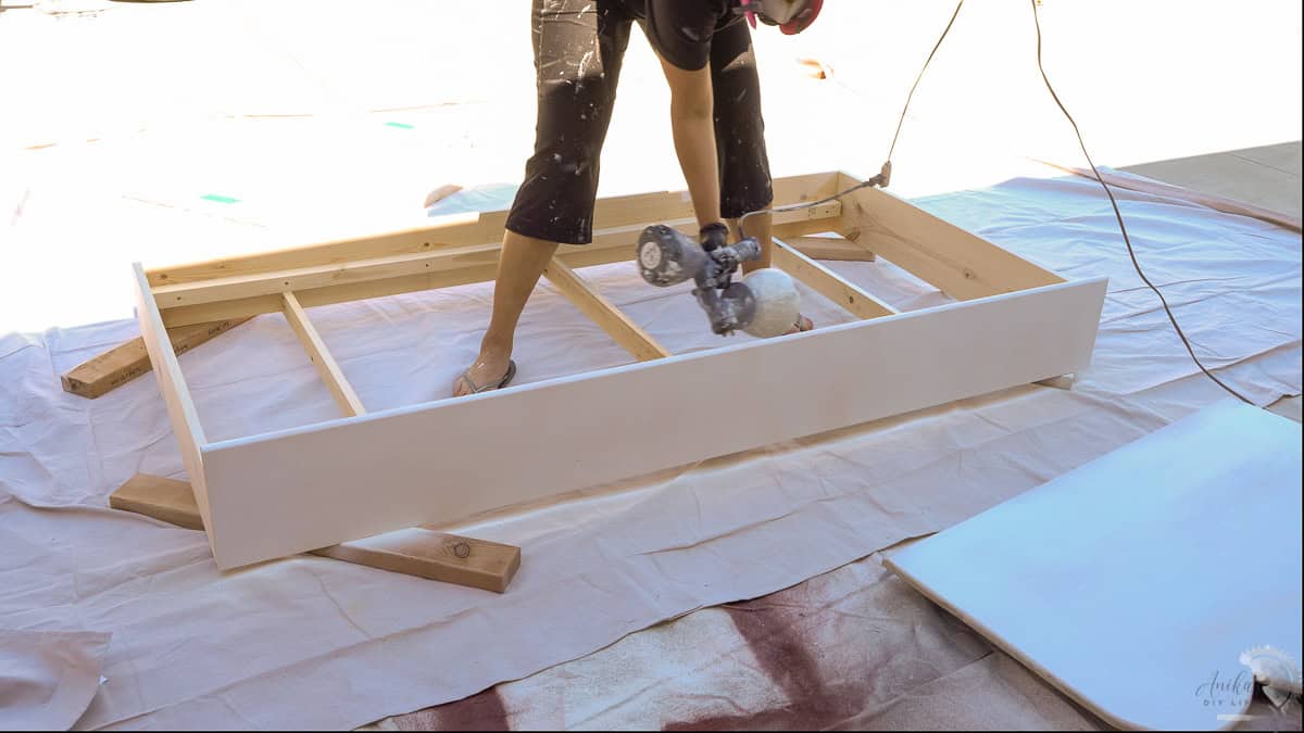 painting the diy trundle bed white with a paint sprayer