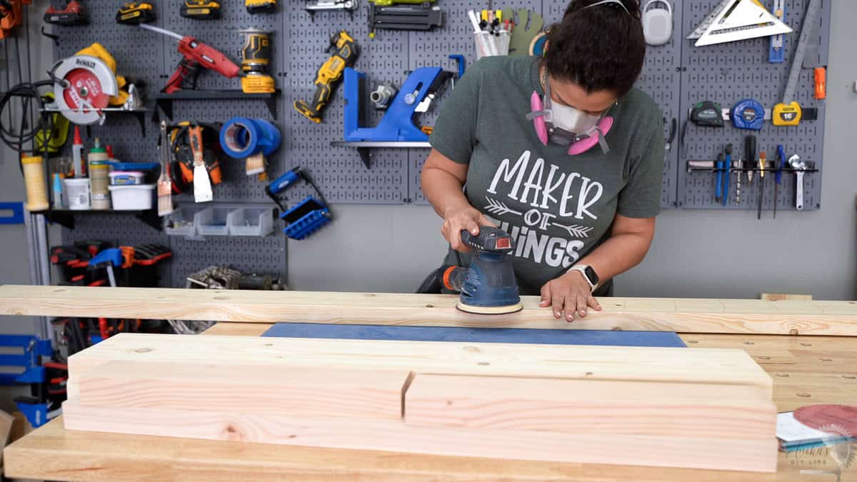 Anika sanding boards for a diy twin bed frame using a random orbital sander