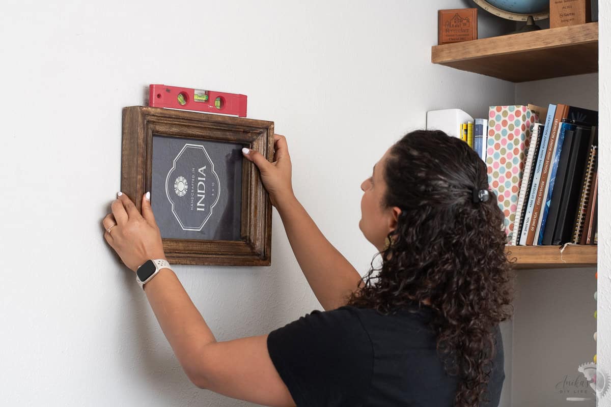 Woman hanging up a picture frame on the wall