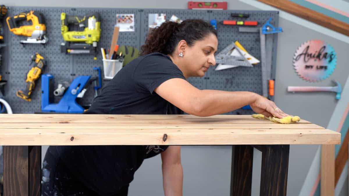 Woman wiping a bench with a tack cloth