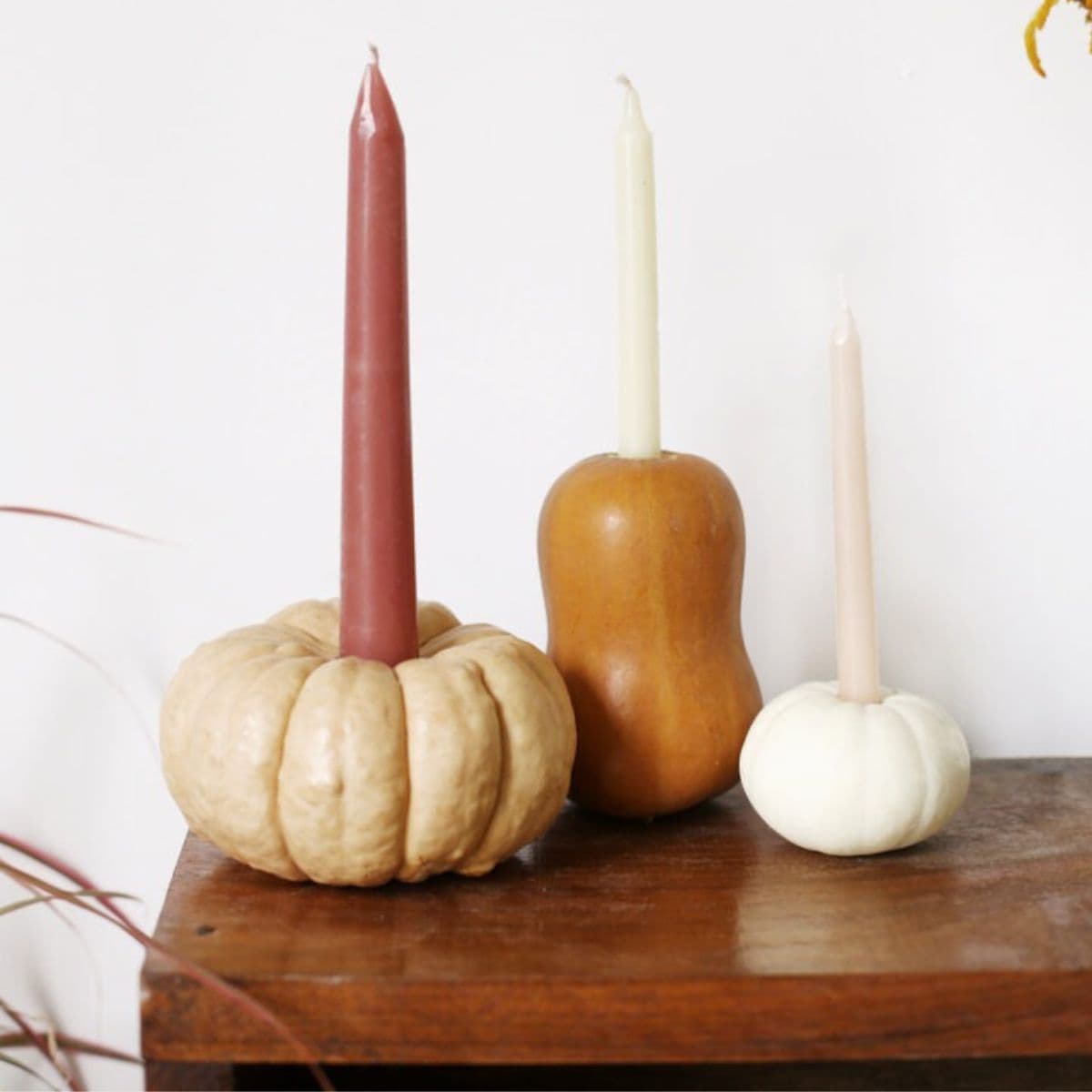 two mini pumpkins and a ghord used as candle holders