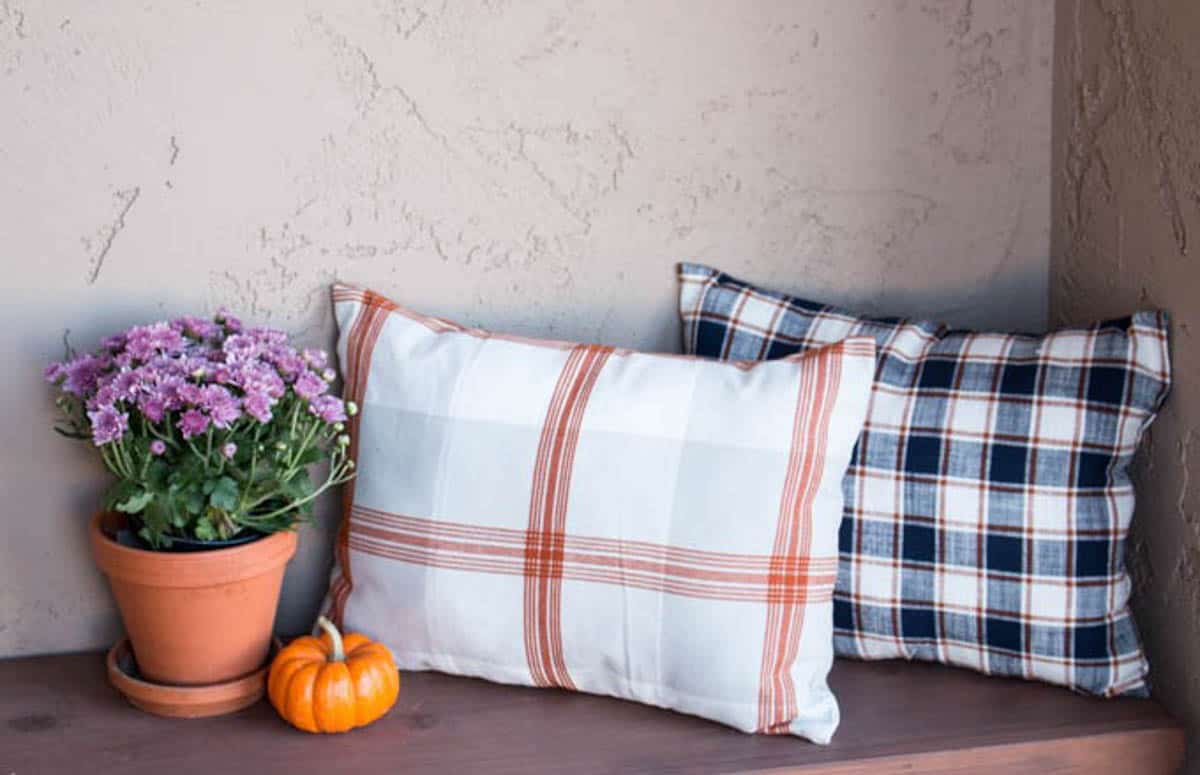 Fall pillows sitting on an porch bench