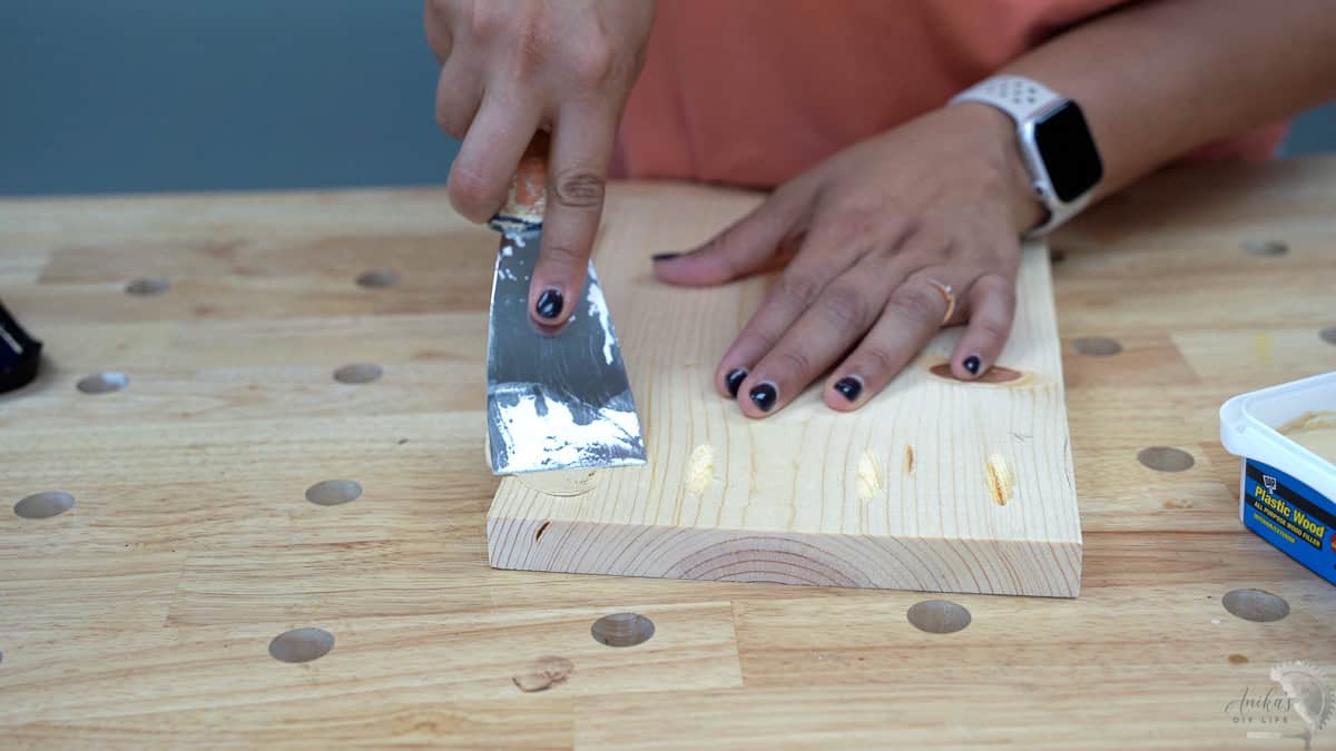 Woman filling pocket hole with wood putty
