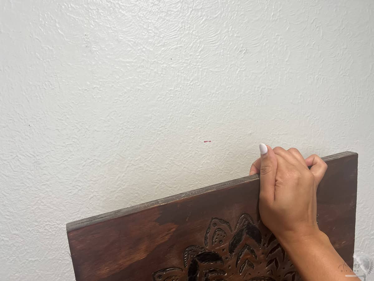 pressing a picture on the wall to transfer the lipstick to hang it on the wall