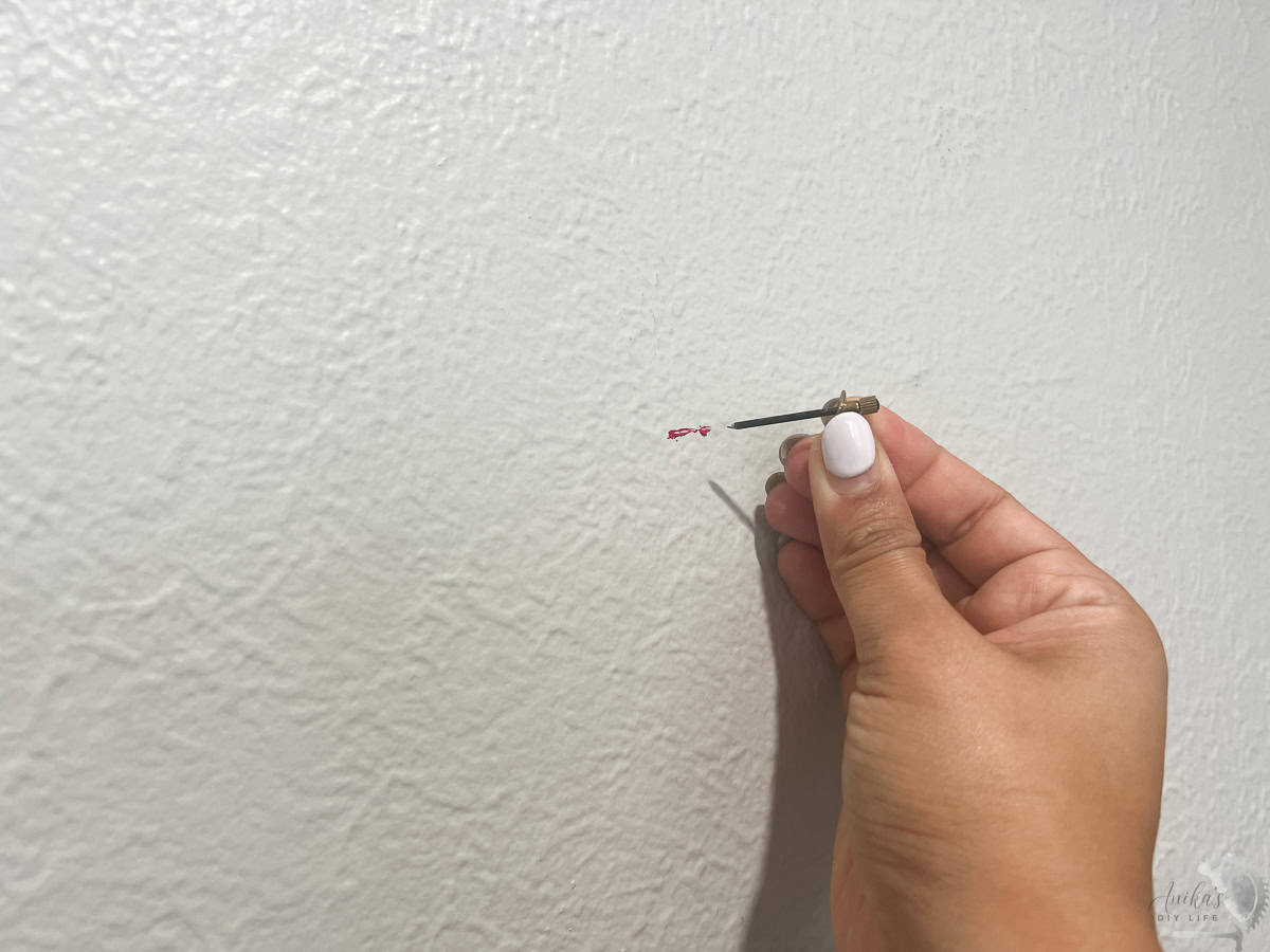 Adding the picture hanger to the wall.