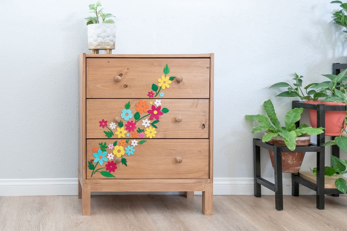 Ikea rast makeover with colorful flowers and leaves in room.