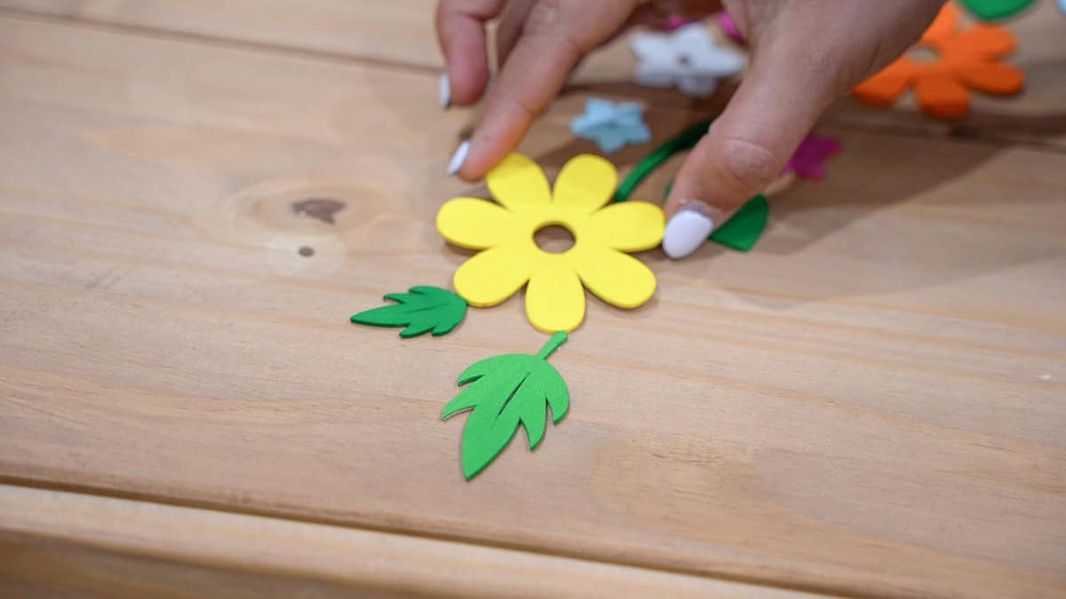 Woman placing Bright yellow flower and green leaves on the dresser