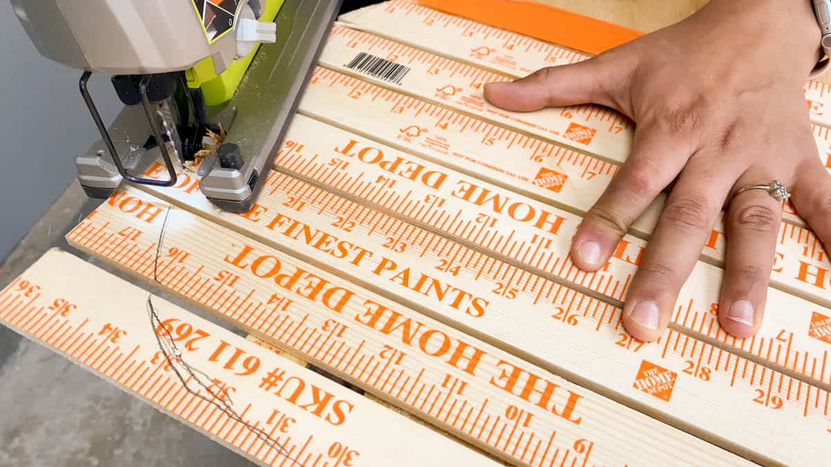 Cutting yardsticks into a pumpkin shape using a jigsaw