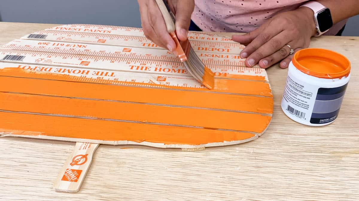 Painting yardstick pumpkin orange