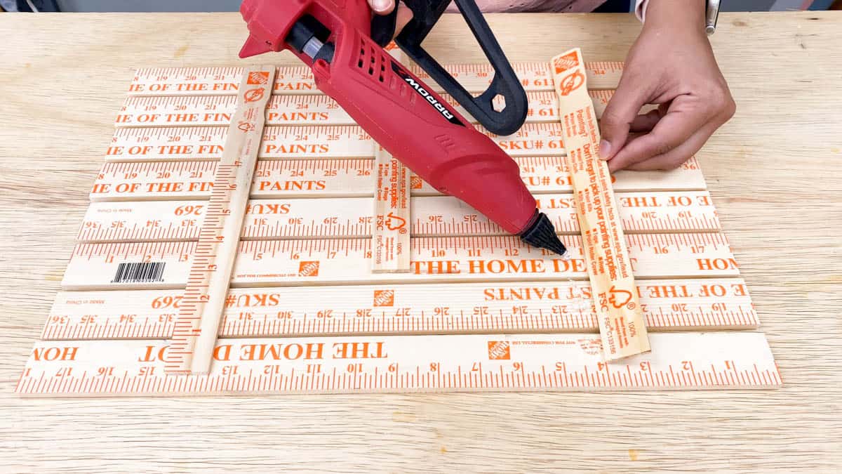 Adding paint sticks to the back with hot glue