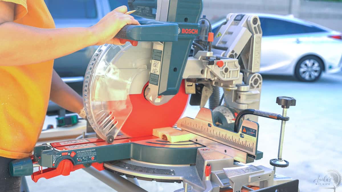 Woman cutting wood on a miter saw