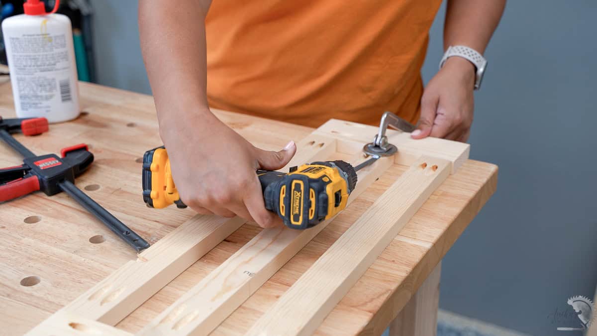 Woman adding pocket hole screws using a power drill to build the frames