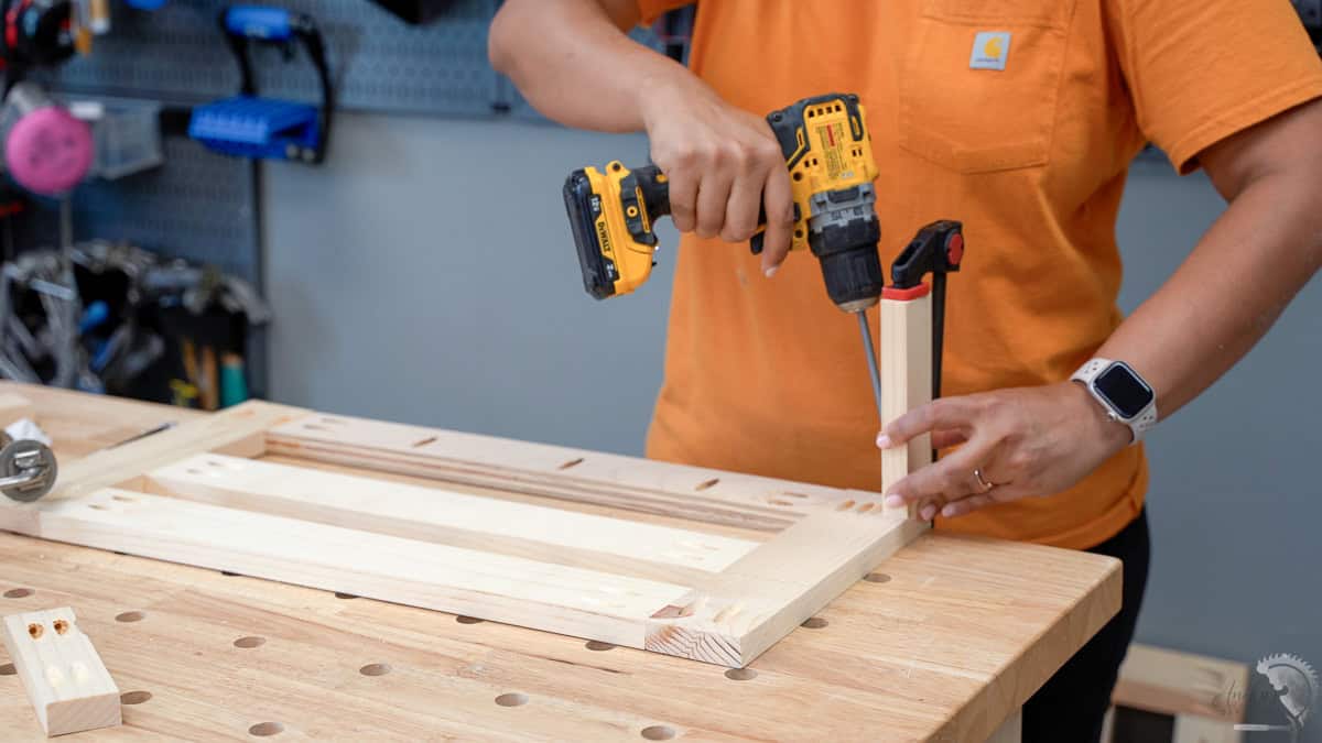 Woman attaching dividers to the frame using pocket hole screws