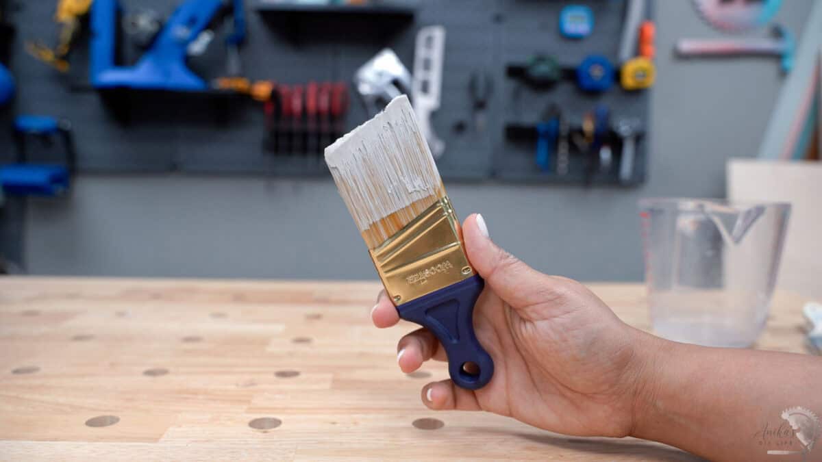 Woman holding a paint brush with dried paint