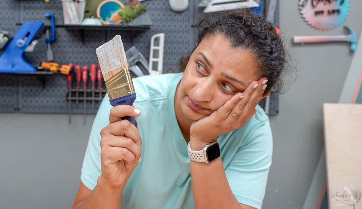 Anika looking at a dried up paint brush