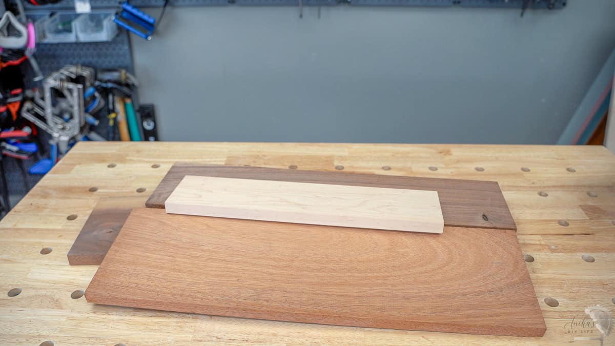 walnut, mahogany, maple boards on a workbench ready to be made into a DIY cutting board