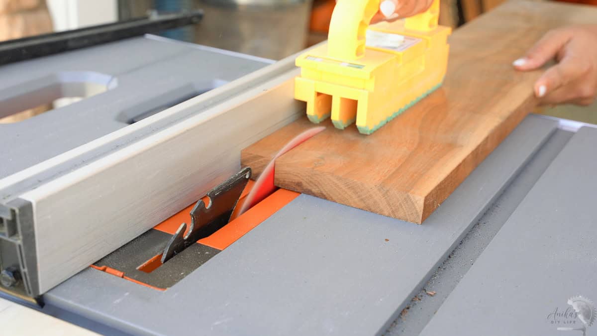 Cutting a mahogany board on the table saw into strips