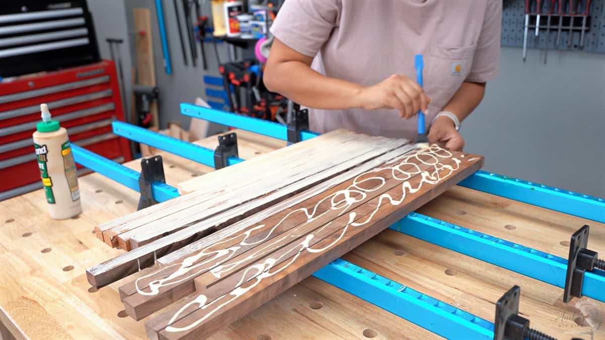 Applying wood glue to boards to prepare them for clamping.