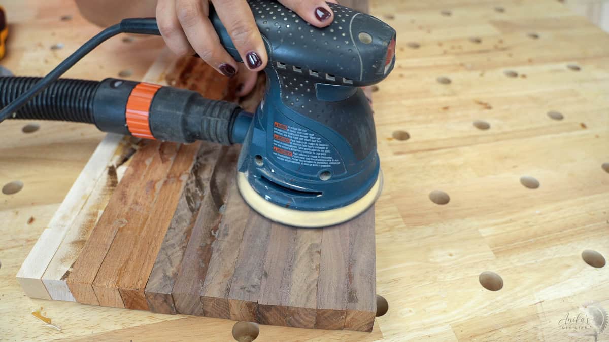 Rough sanding the cutting board with a sander