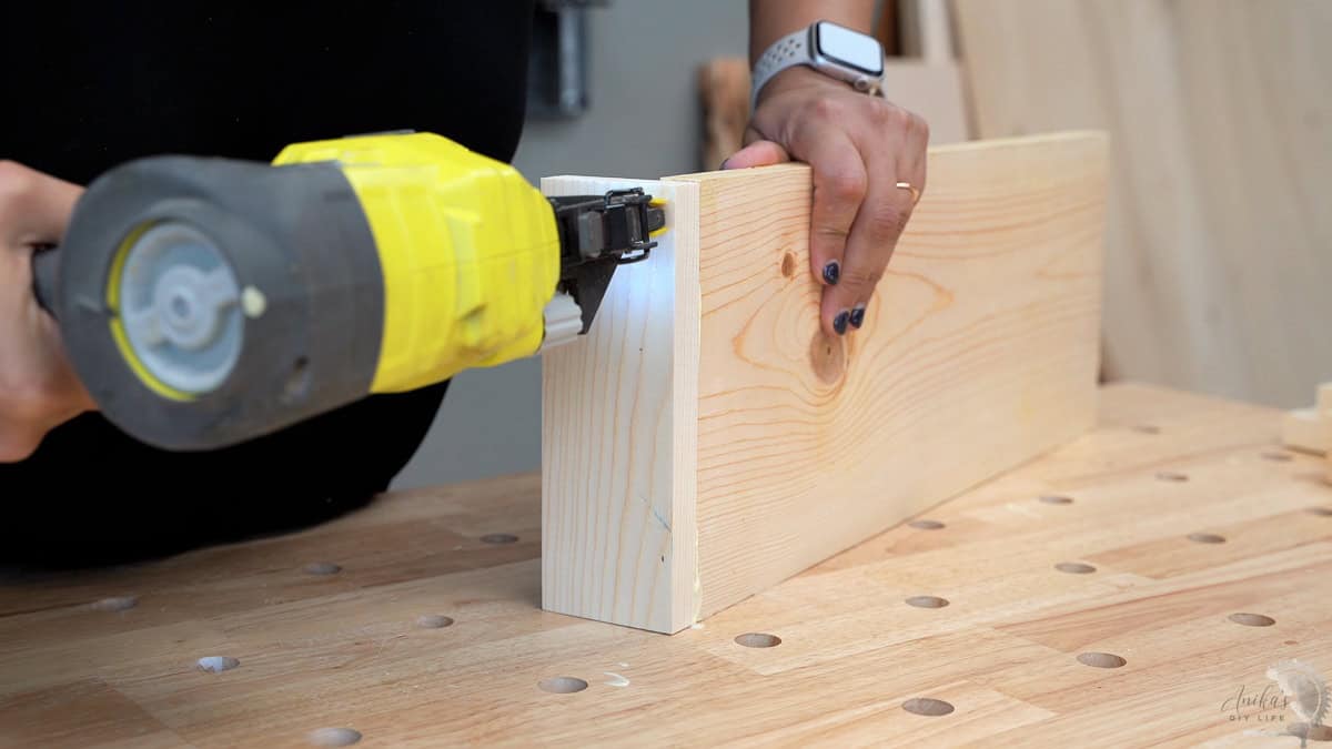 Attaching the first side to the base using a nail gun