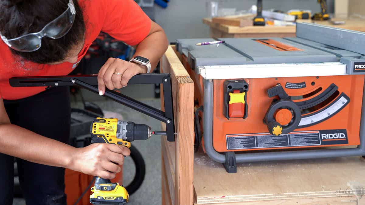 attaching the folding table brackets to the table saw stand