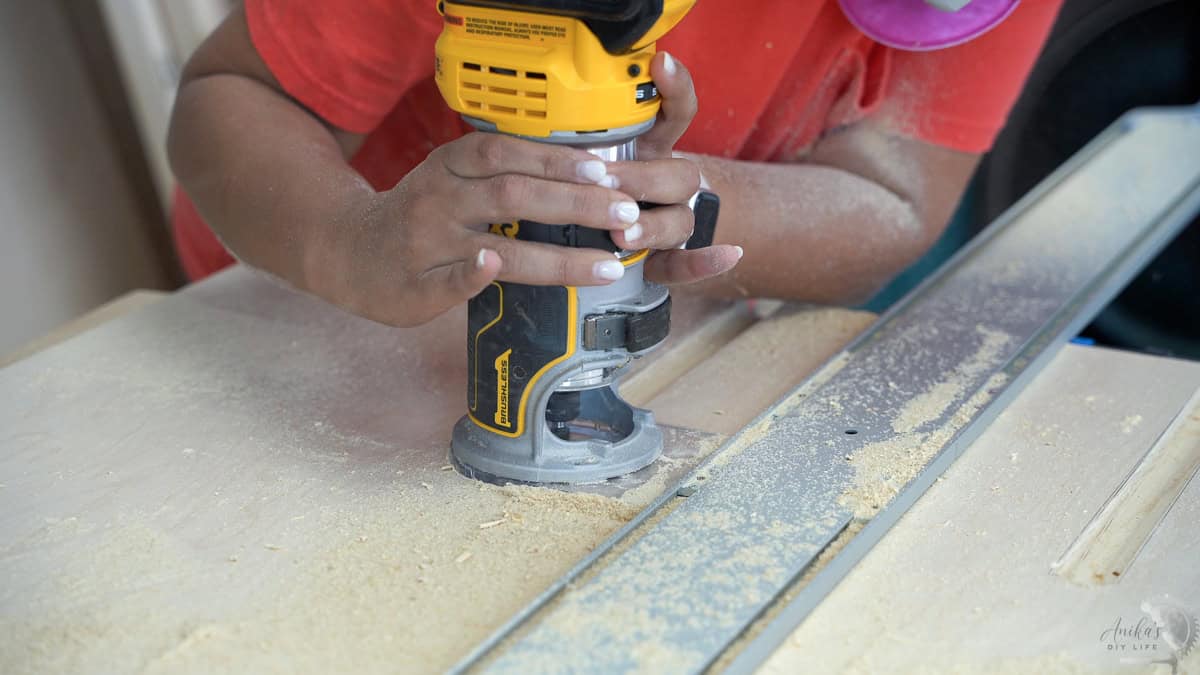 routing the grooves using a compact router in plywood