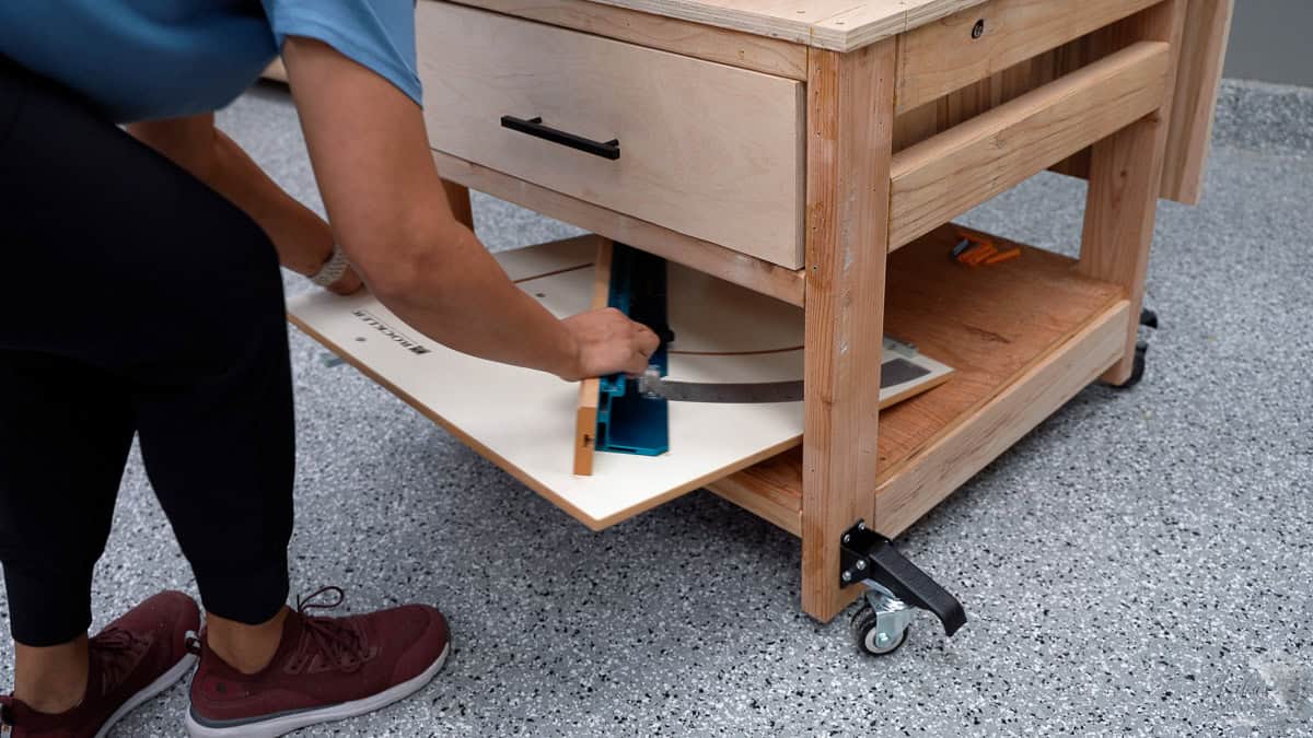 placing the crosscut sled into the shelf of the table saw stand