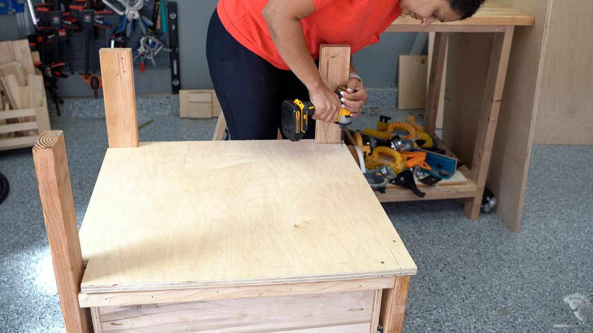 Attaching the top shelf using wood screws to the table saw stand
