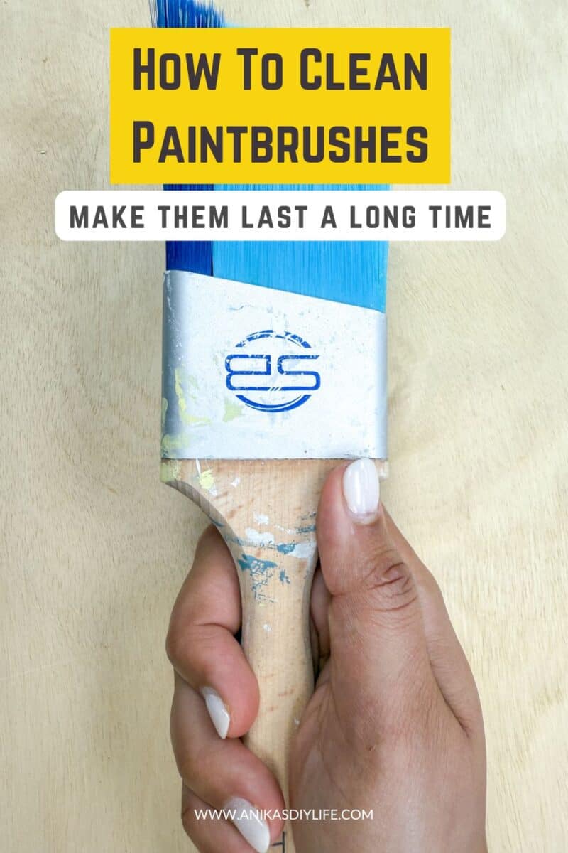 woman holding paintbrush with text overlay - how to clean paintbrushes