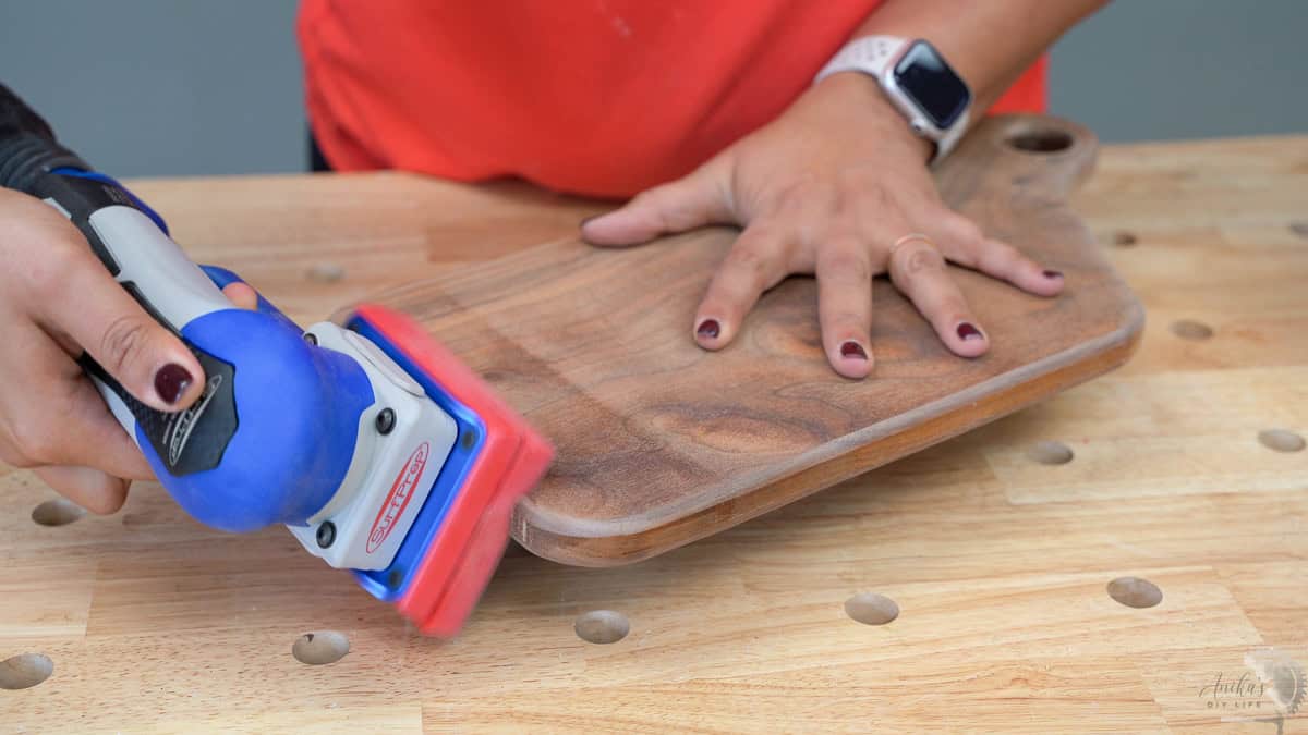 Sanding the cutting board with a foam sanding pad