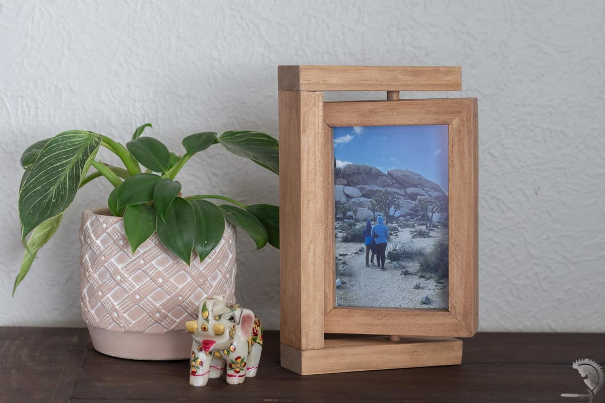 Wood DIY Rotating Picture frame on a desk next to a plant