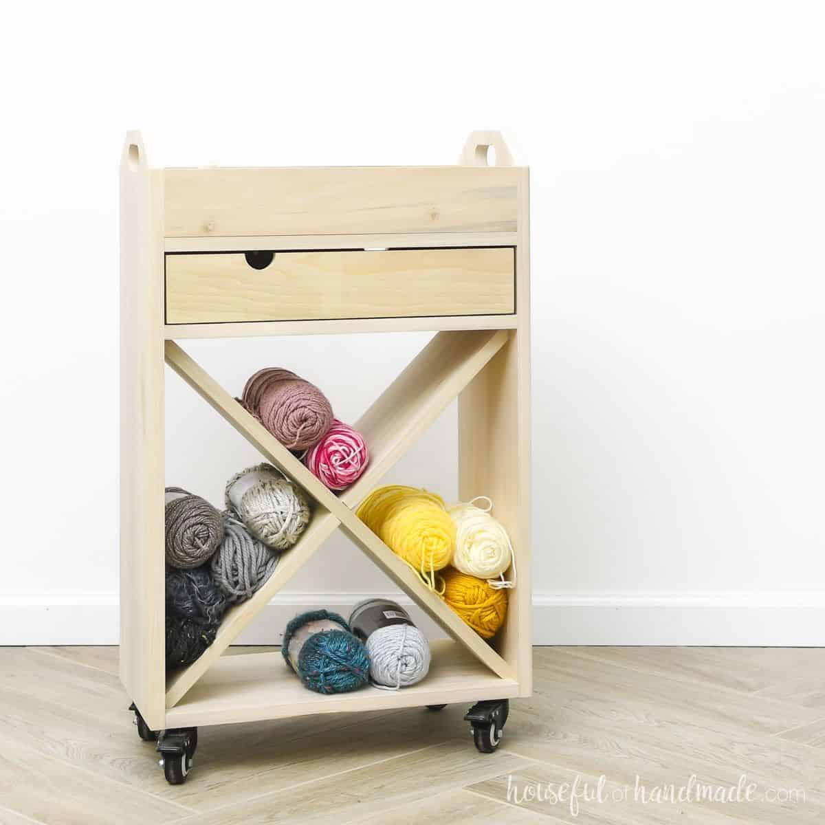 DIY wood craft cart with drawers and X design shelves to hold yarn