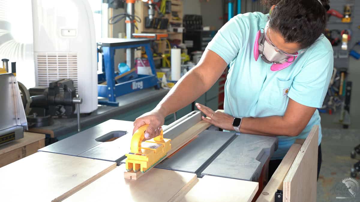 Anika making the groove in the 1x2 board on a table saw
