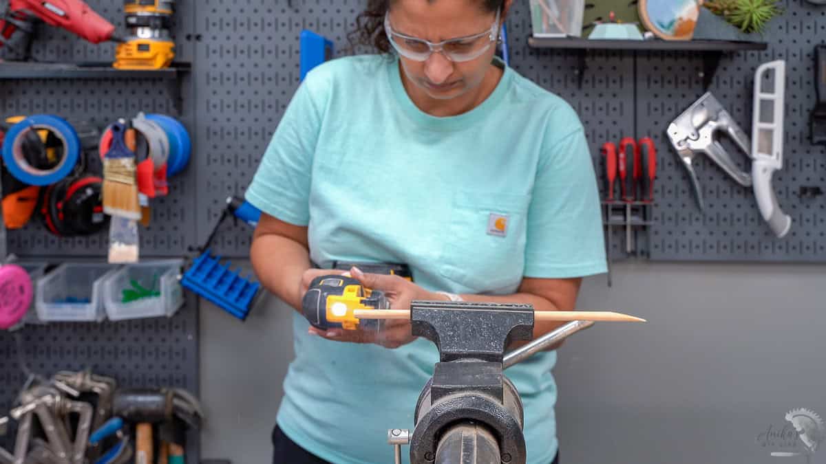 Anika cutting the dowel rod using an oscillating tool