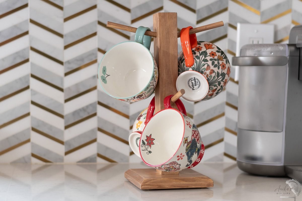 DIY mug tree with colorful mugs on kitchen counter