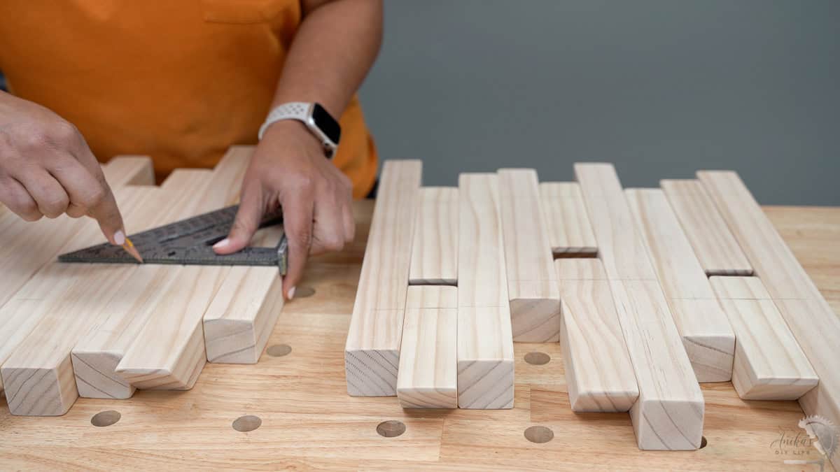 Using a speed square to mark location of the holes for the dowels.