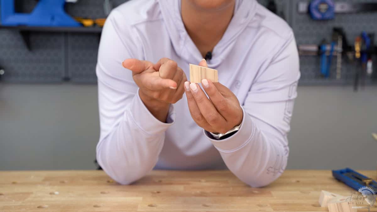 Anika showing the piece of 2x2 with one end cut at 15 degrees