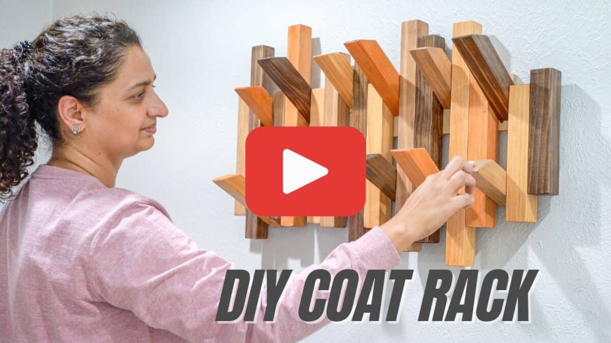 Anika pulling down hook of piano coat rack with text overlay and YouTube play button
