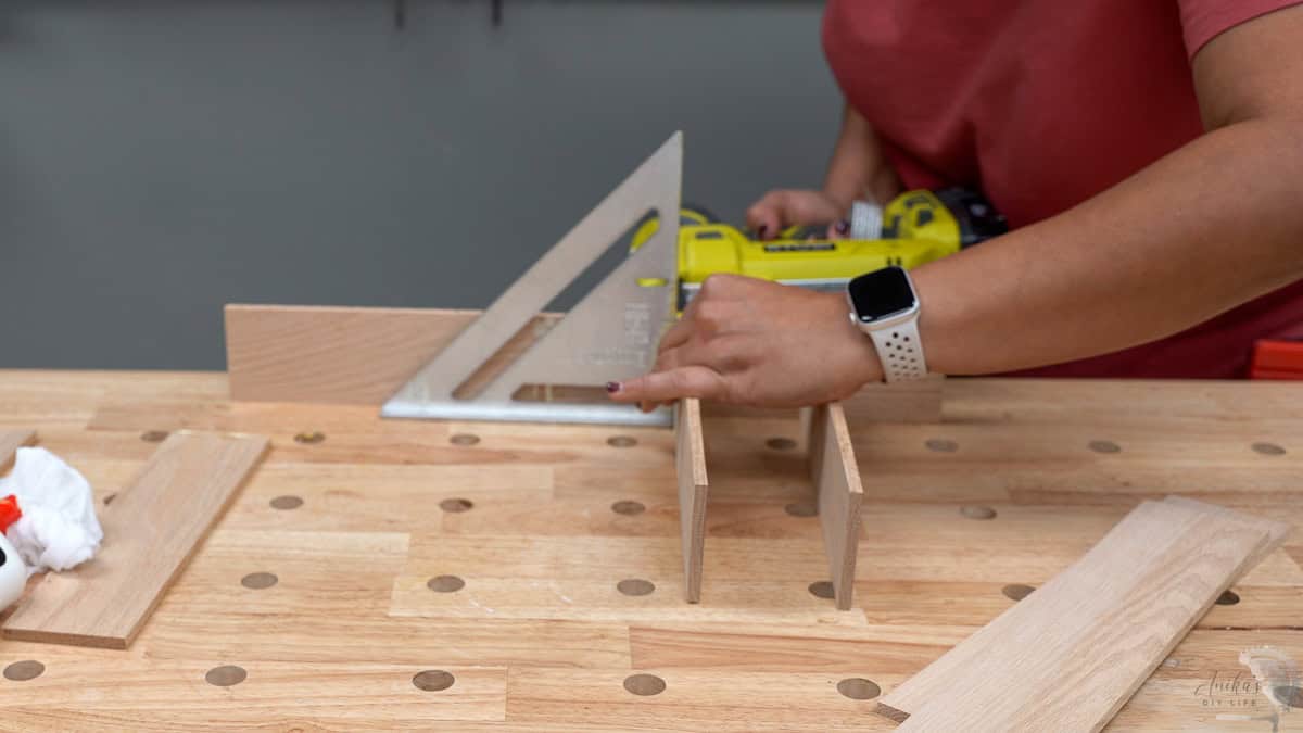 attaching the wood boards together using wood glue and pin nails.