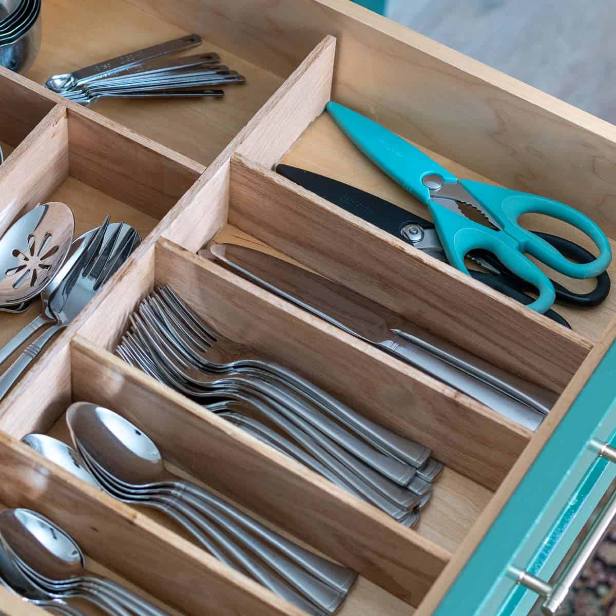 Learn how to build a custom wood DIY kitchen drawer organizer. Perfectly sized-compartments, easy assembly, and a professional finish help keep your utensils neat and organized!