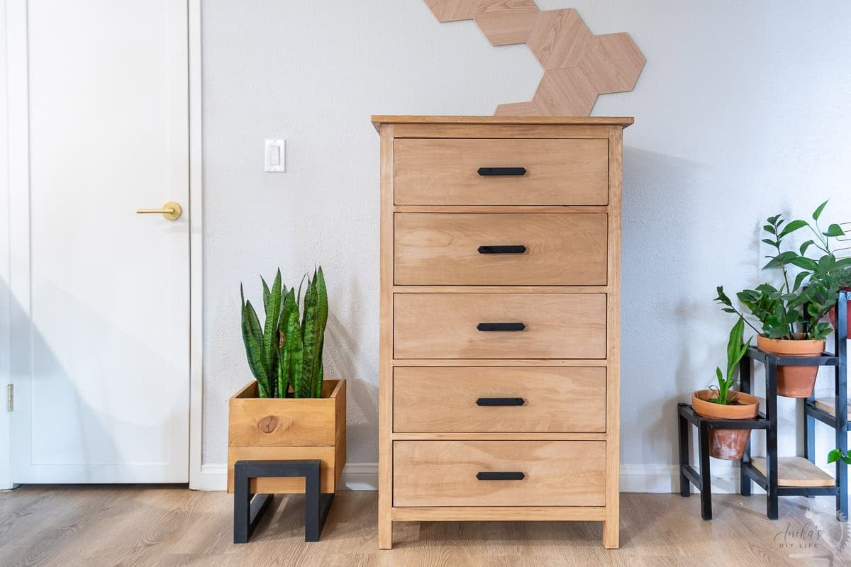 Brown DIY Dresser with 5 drawers in front of a gray wall with plants next to it in a planter